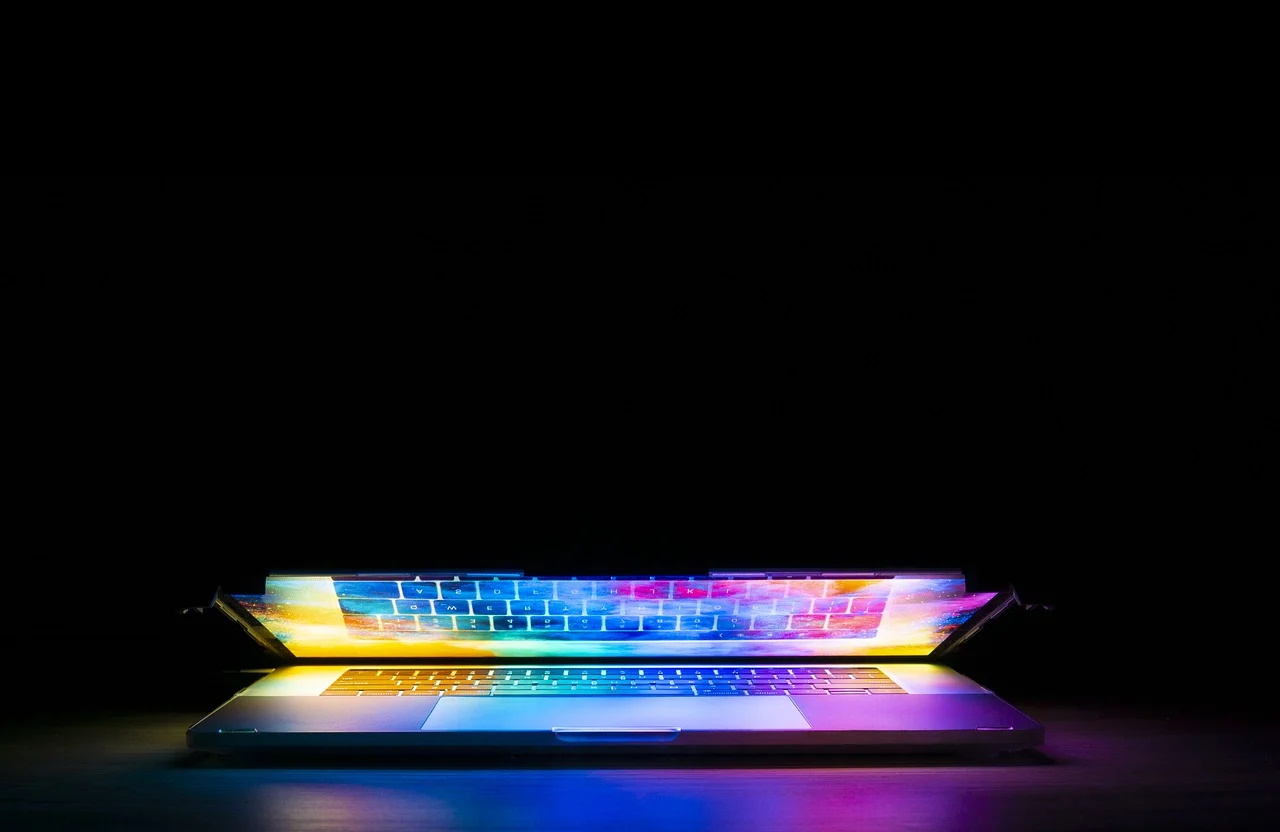 Laptop partially open with bright colors coming out of it